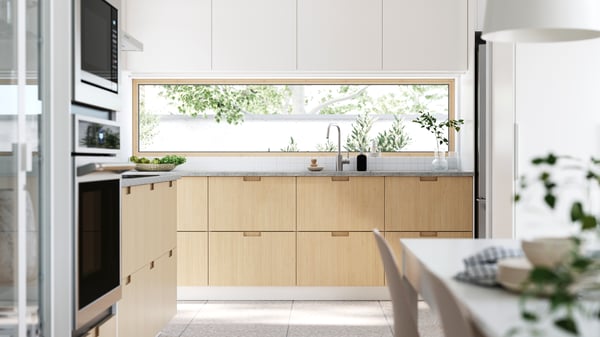 A sun-drenched kitchen with windows facing the garden. FRÖJERED kitchen fronts, in bamboo, are combined with fronts in white.