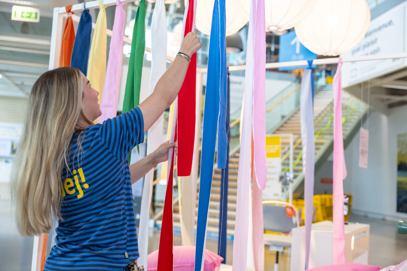 Une collaboratrice IKEA en train de decorer un espace en magasin