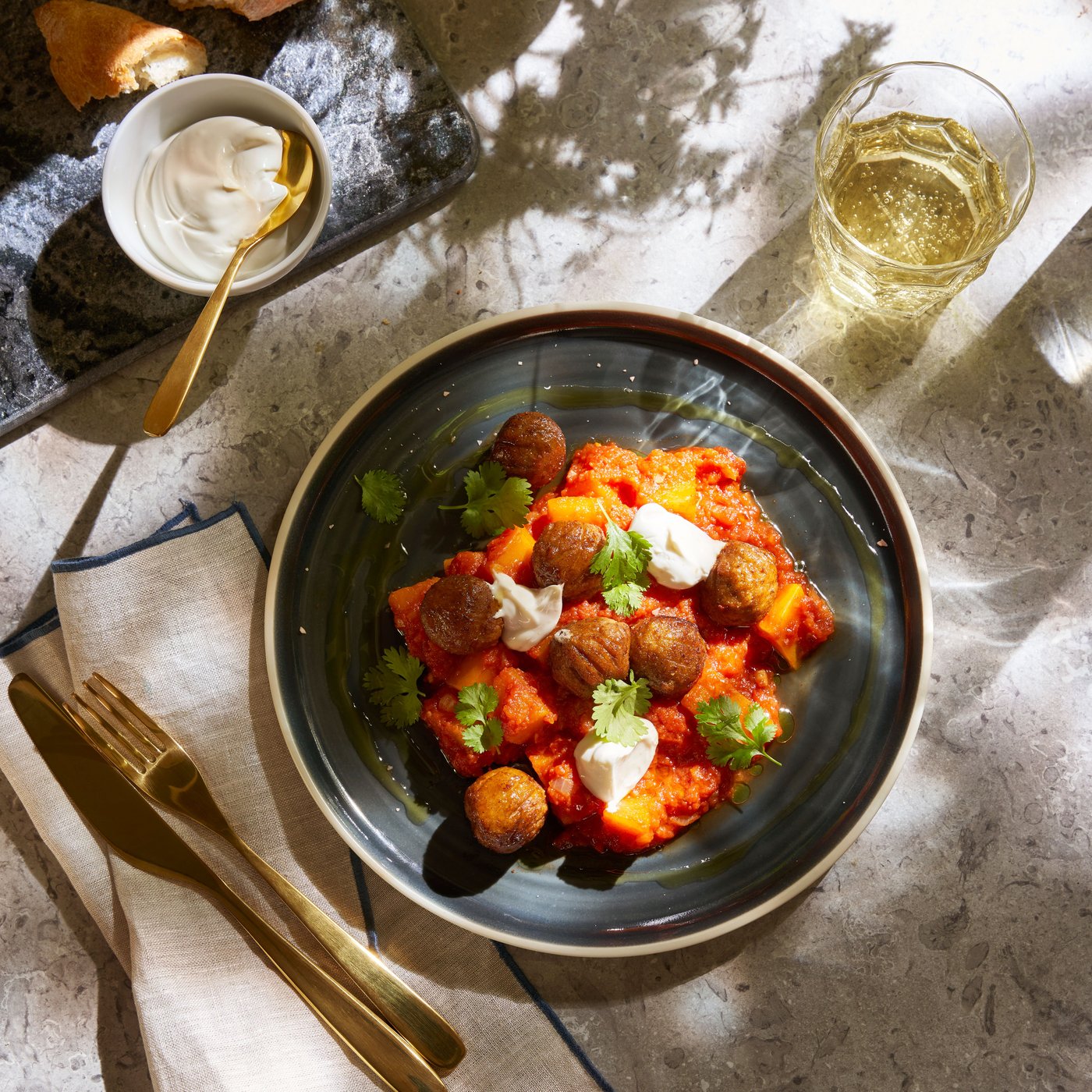 Krupan kadar tri zlatno-braon kolača od krompira na drvenoj dasci, s vidljivim zelenim biljem i crvenim mrljama. U prvom planu je kolač presečen na pola, čime je otkrivena meka unutrašnjost iz koje izlazi para