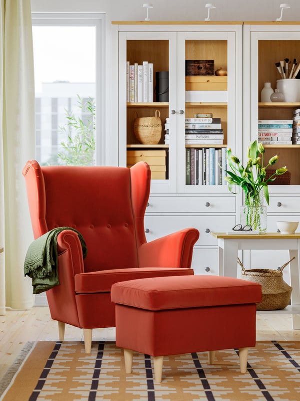 A Tommaboda brown-red STRANDMON wing chair with footstool in the living room
