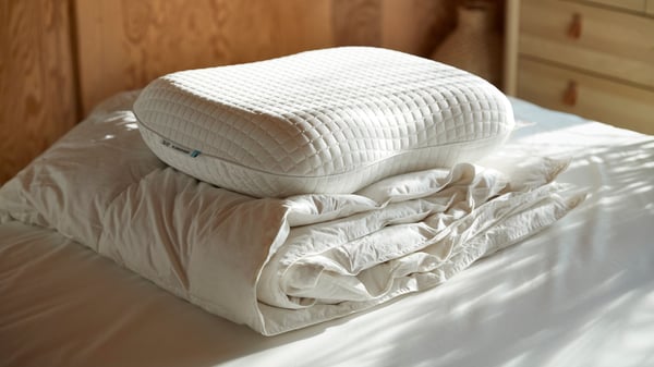 KLUBBSPORRE pillows and duvet stacked on bedsheet