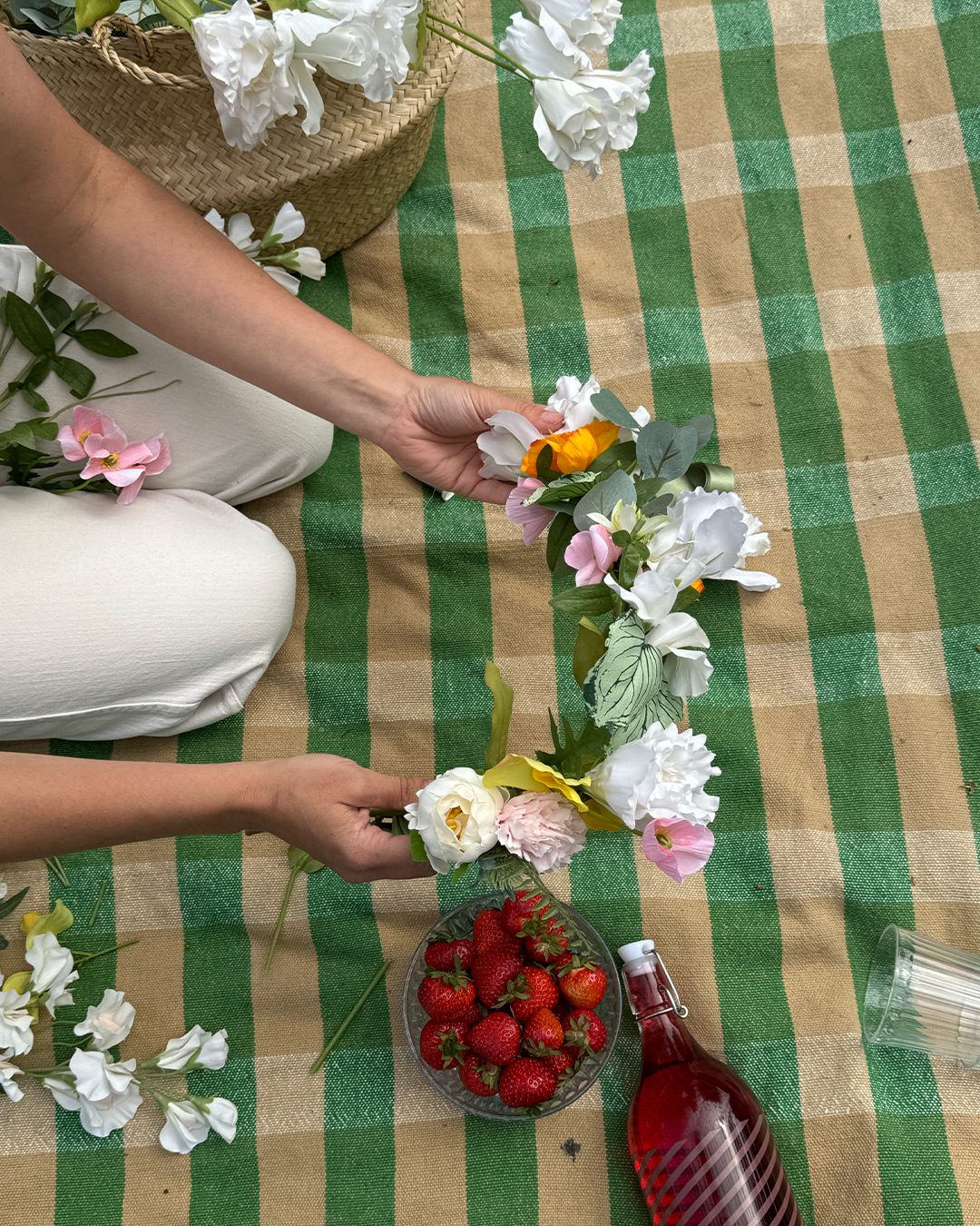 En person håller i en midsommarkrans.
