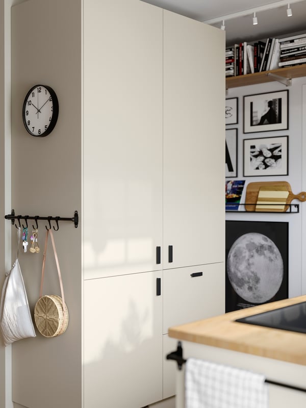 A small and bright kitchen has SEKTION kitchen cabinets and an integrated fridge/freezer with beige HAVSTORP fronts.