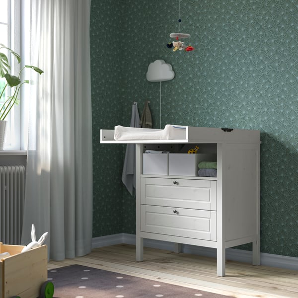 Une table à langer blanche dans une chambre à coucher.