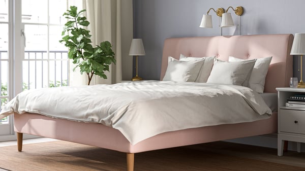 An IKEA pink bed with white bedding