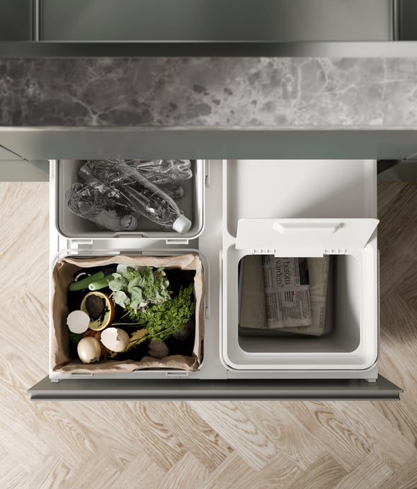 A light grey HÅLLBAR bin with lid in the kitchen.