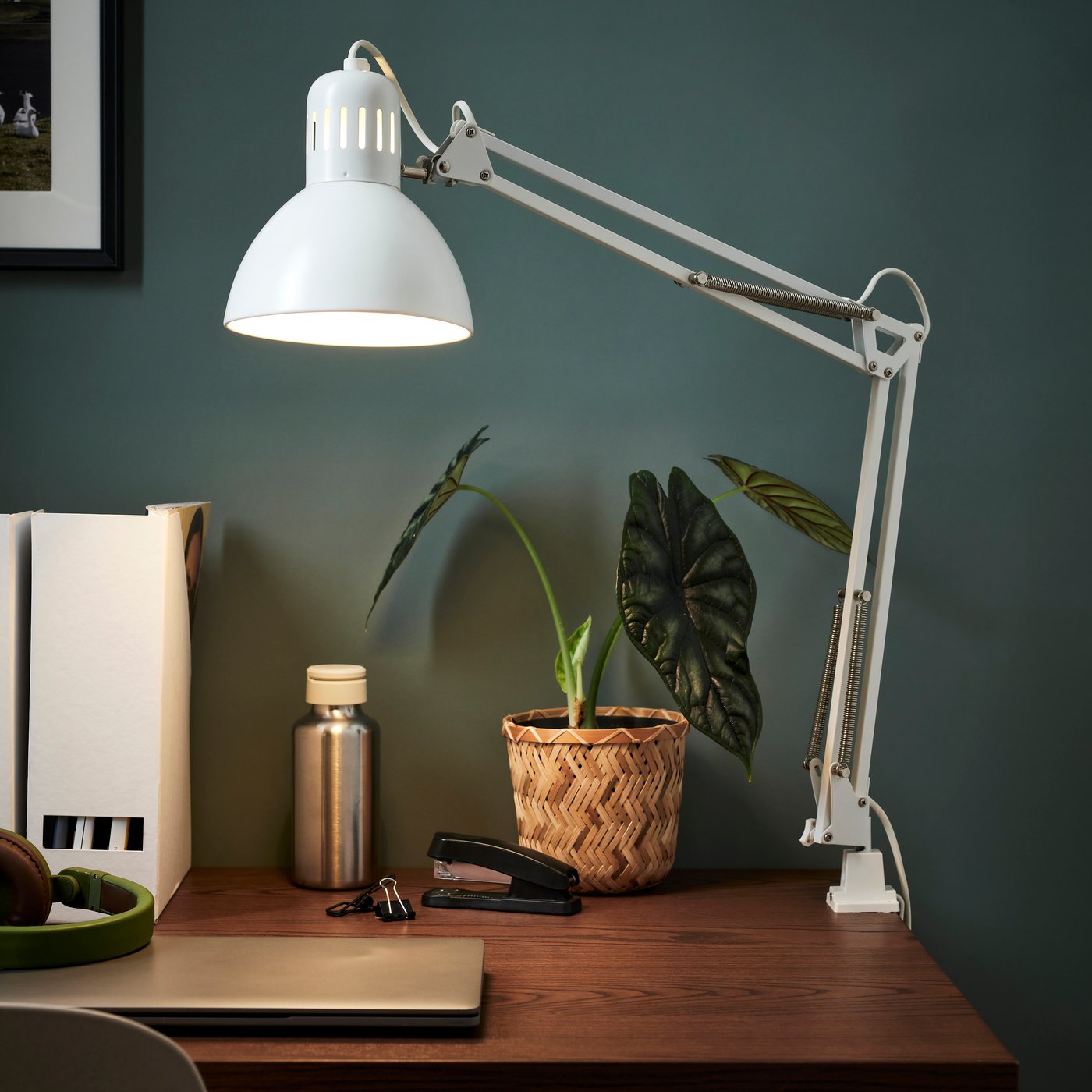 A white TERTIAL work lamp sits on a dark wooden desk.