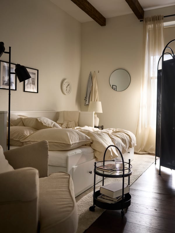 Das HEMNES Tagesbett rechts und der GRÅFJÄLLET Raumteiler trennen den Bereich mit dem Gästebett vom Rest des Zimmers.