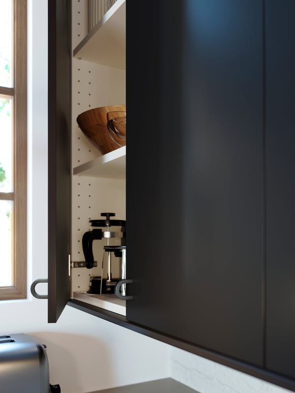 A wall cabinet with BORGHAMN handles, NICKEBO doors in matte anthracite, UTRUSTA shelves and an UPPHETTA coffee/tea maker.