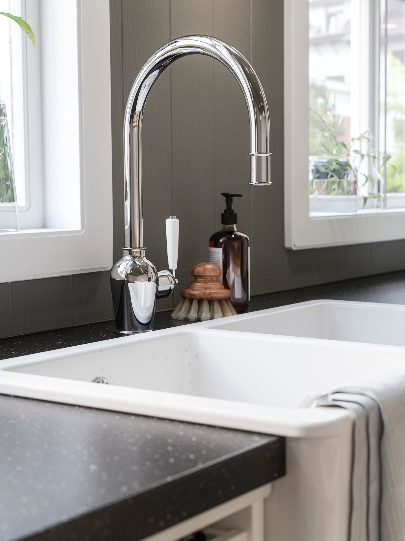 Gambar dekat sink dapur berwarna putih dengan paip campuran bersadur krom yang kilat.