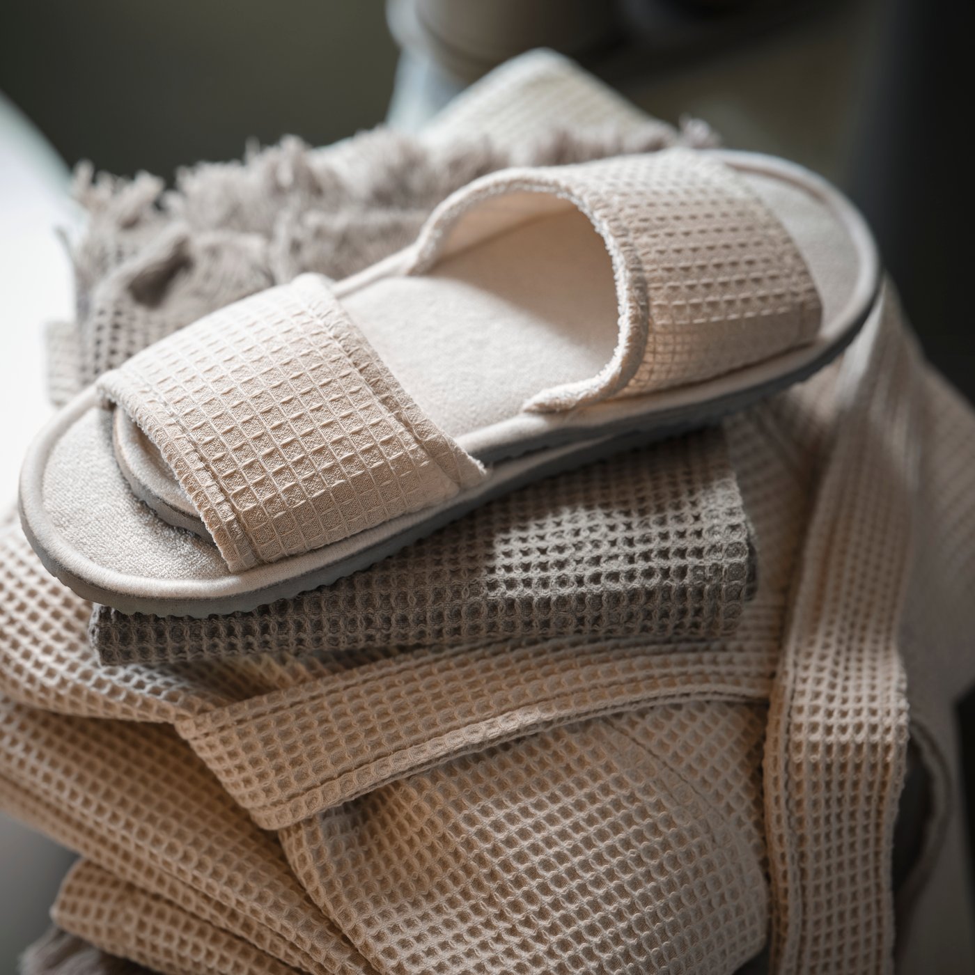 Béžové pantofle SKOVELSJÖN složené na županu.