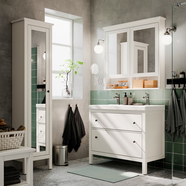 a traditional, well-organized HEMNES bathroom with green tiles, green textile accents. Tall, white HEMNES cabinet beside.
