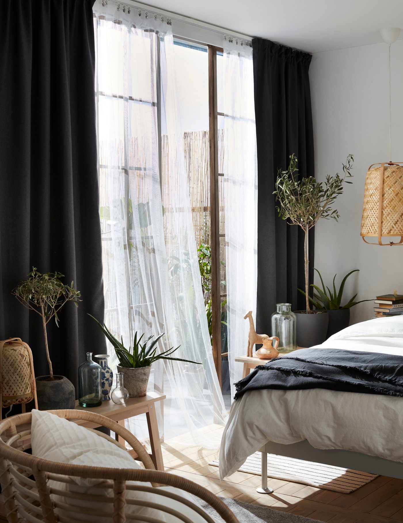 En ODDRUN pledd med gardiner i et soverom.