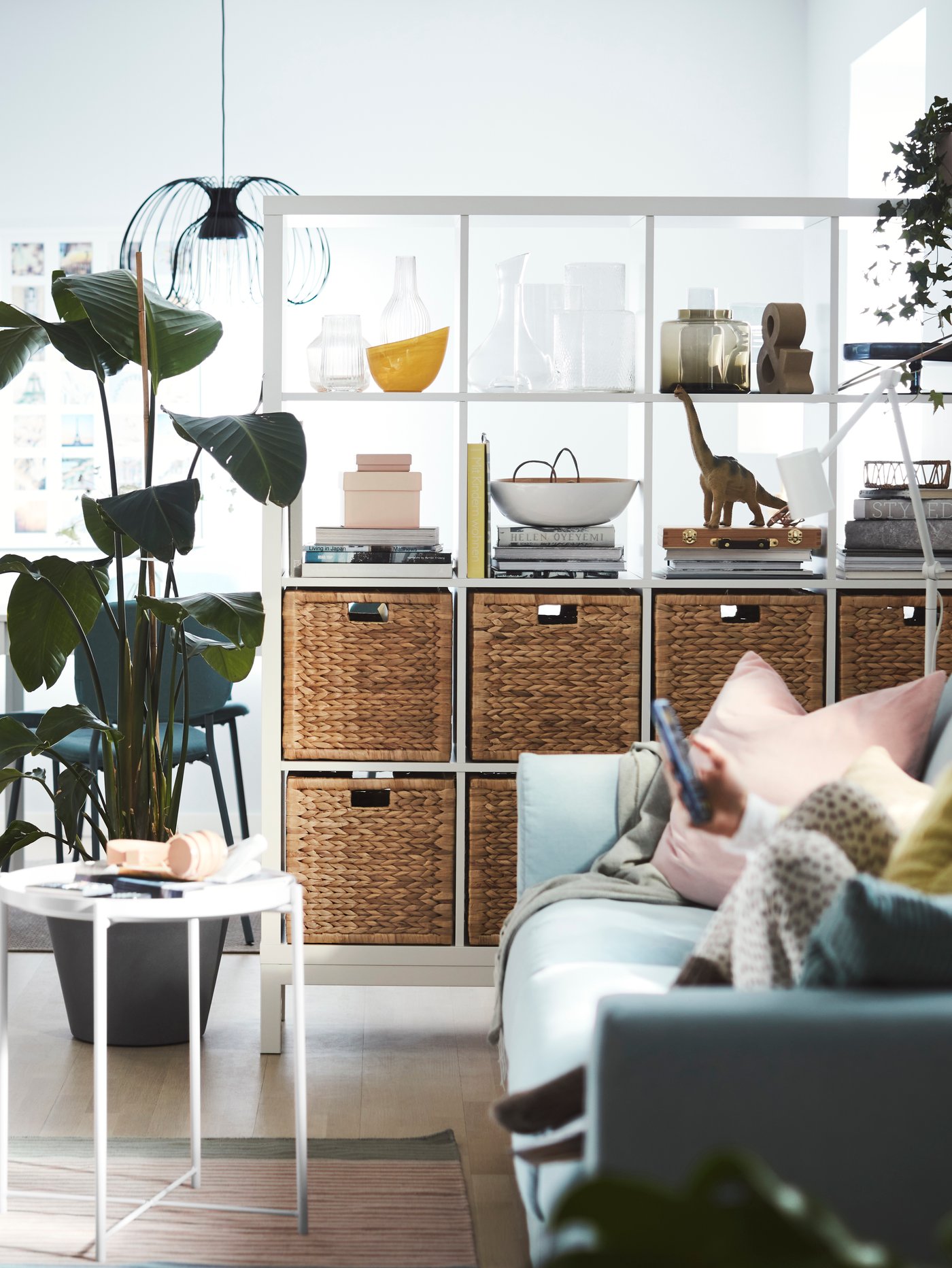 Olohuoneessa on tilanjakajana valkoinen Kallax-hylly, jonka alarivissä on rottinkiset BRANÄS-korit.