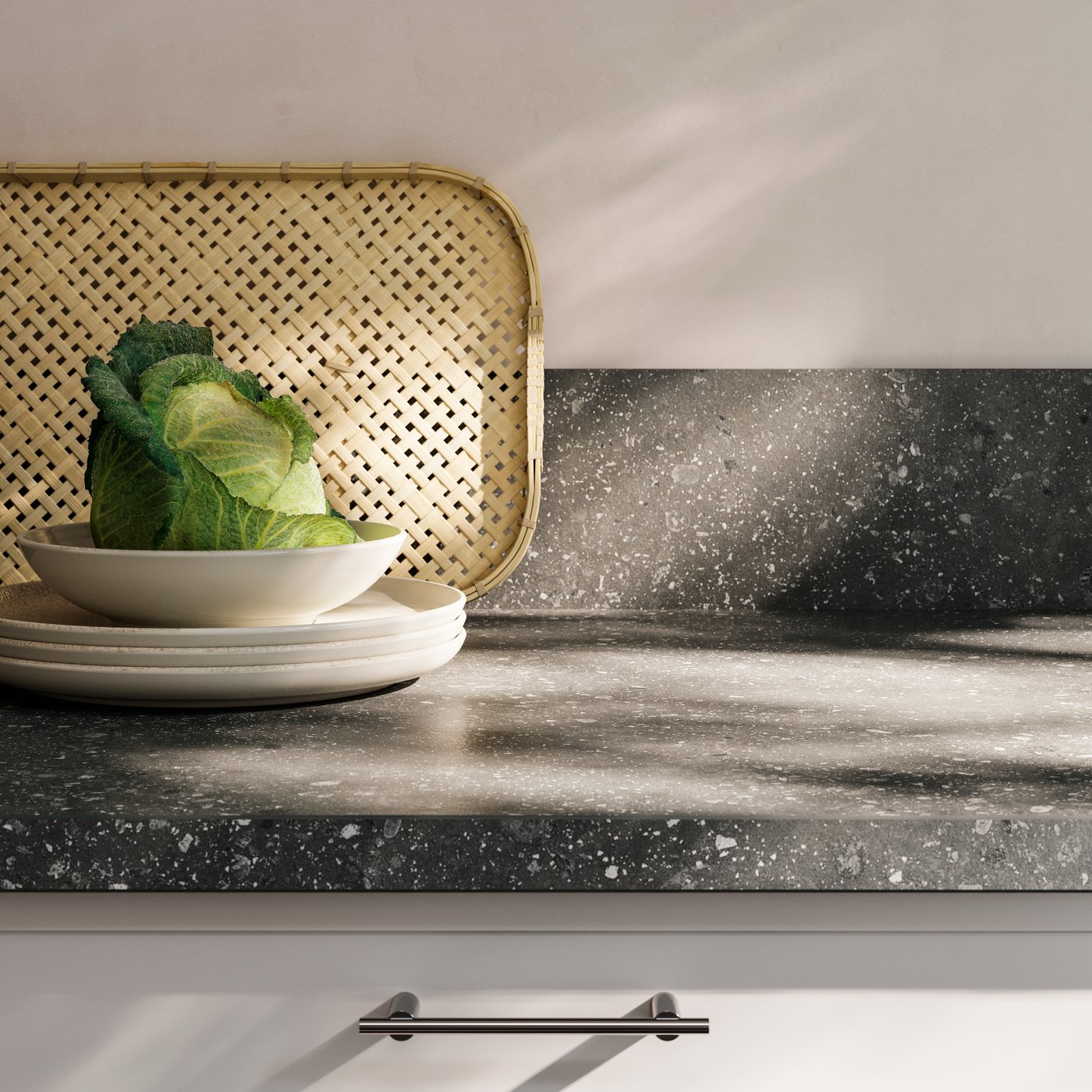 Part of a kitchen featuring an EKBACKEN laminate worktop in grey terrazzo effect combined with SIBBARP laminate wall panel.