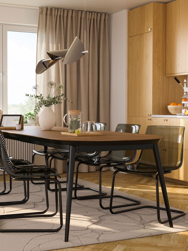 A black/walnut veneer TJÄRKIL extendable table in the dining room