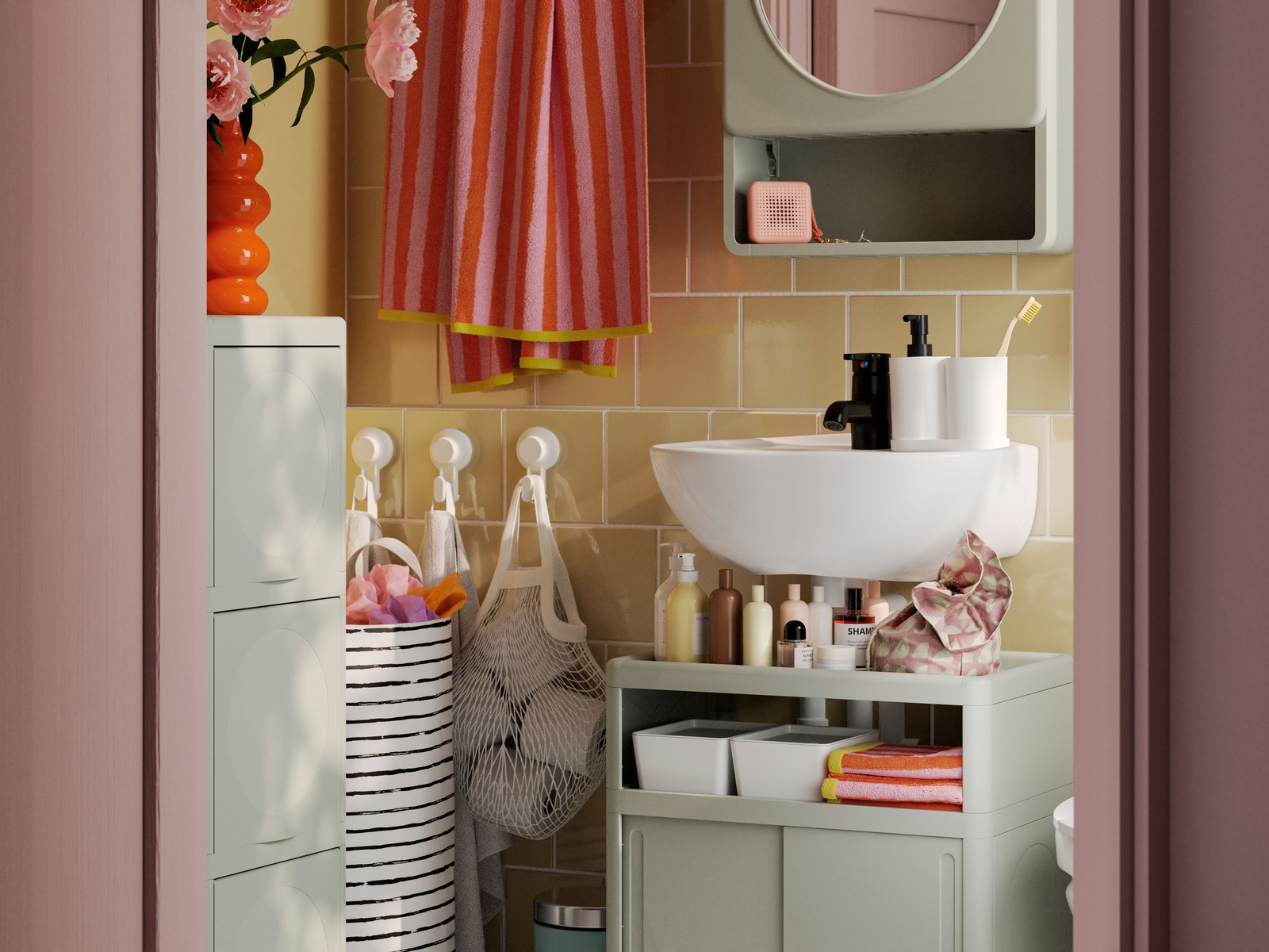 A small, yellow-tiled bathroom has a green IVÖSJÖN wash-basin base cabinet, a cabinet with door and a mirror cabinet.