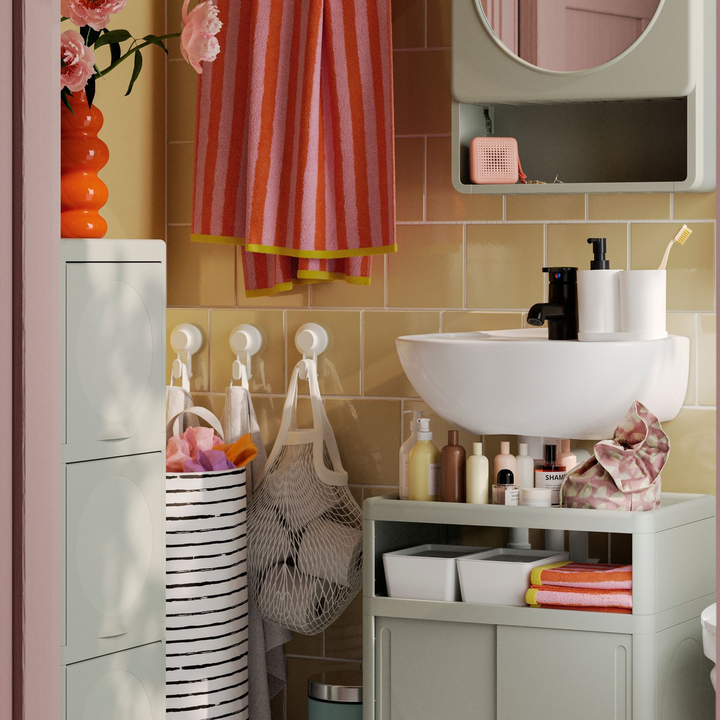 A small, yellow-tiled bathroom has a green IVÖSJÖN wash-basin base cabinet, a cabinet with door and a mirror cabinet.