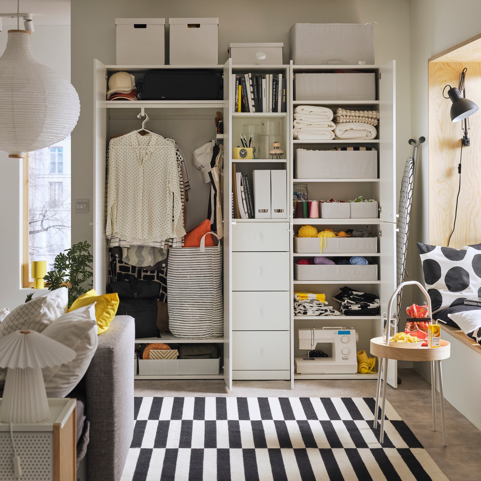 Clothes, storage boxes and everyday items arranged in a LASTARE wardrobe combination in a living-area setting.