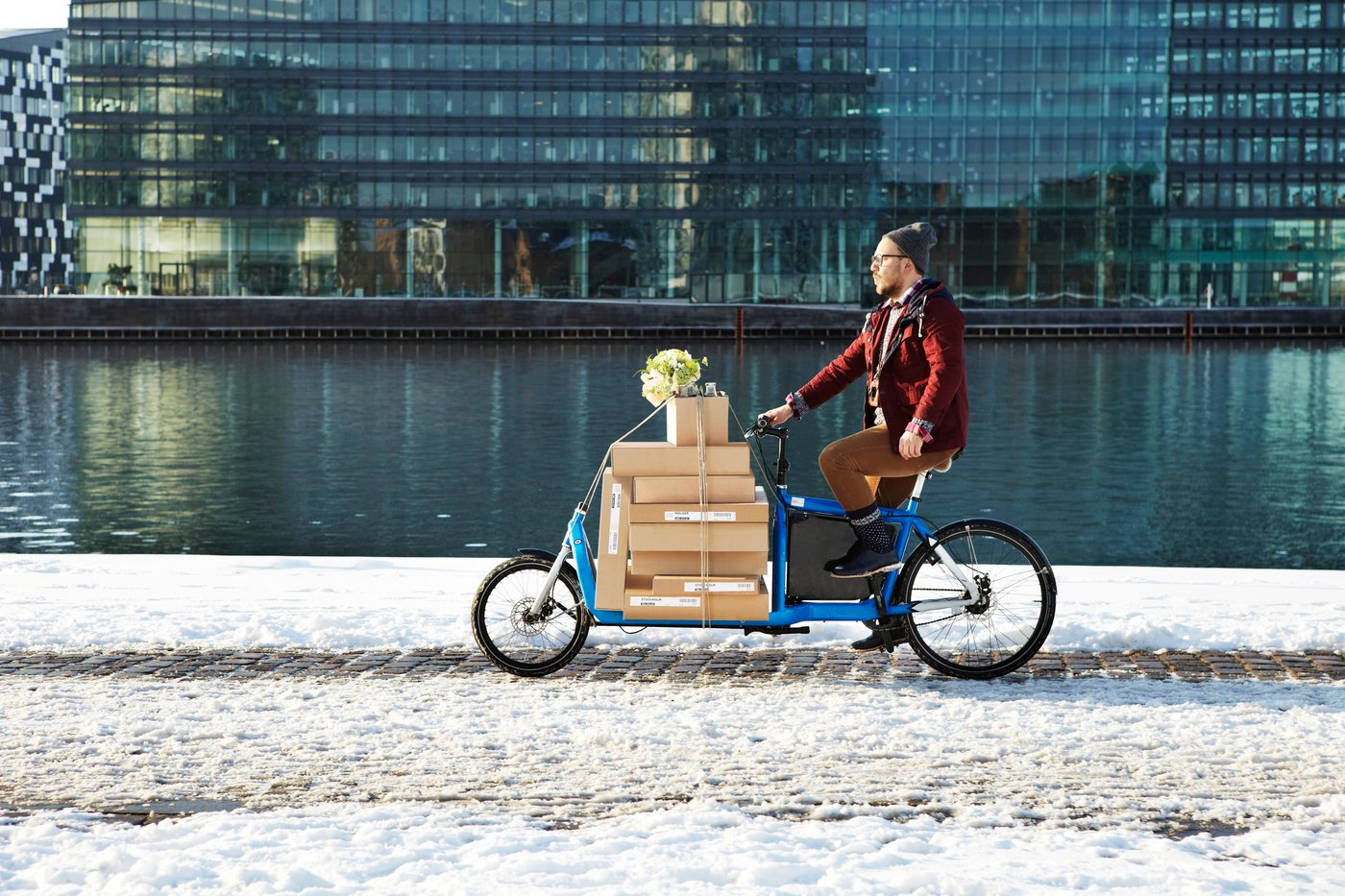 Eine Person transportiert IKEA Pakete mit Hilfe eines E-Lastenrads.