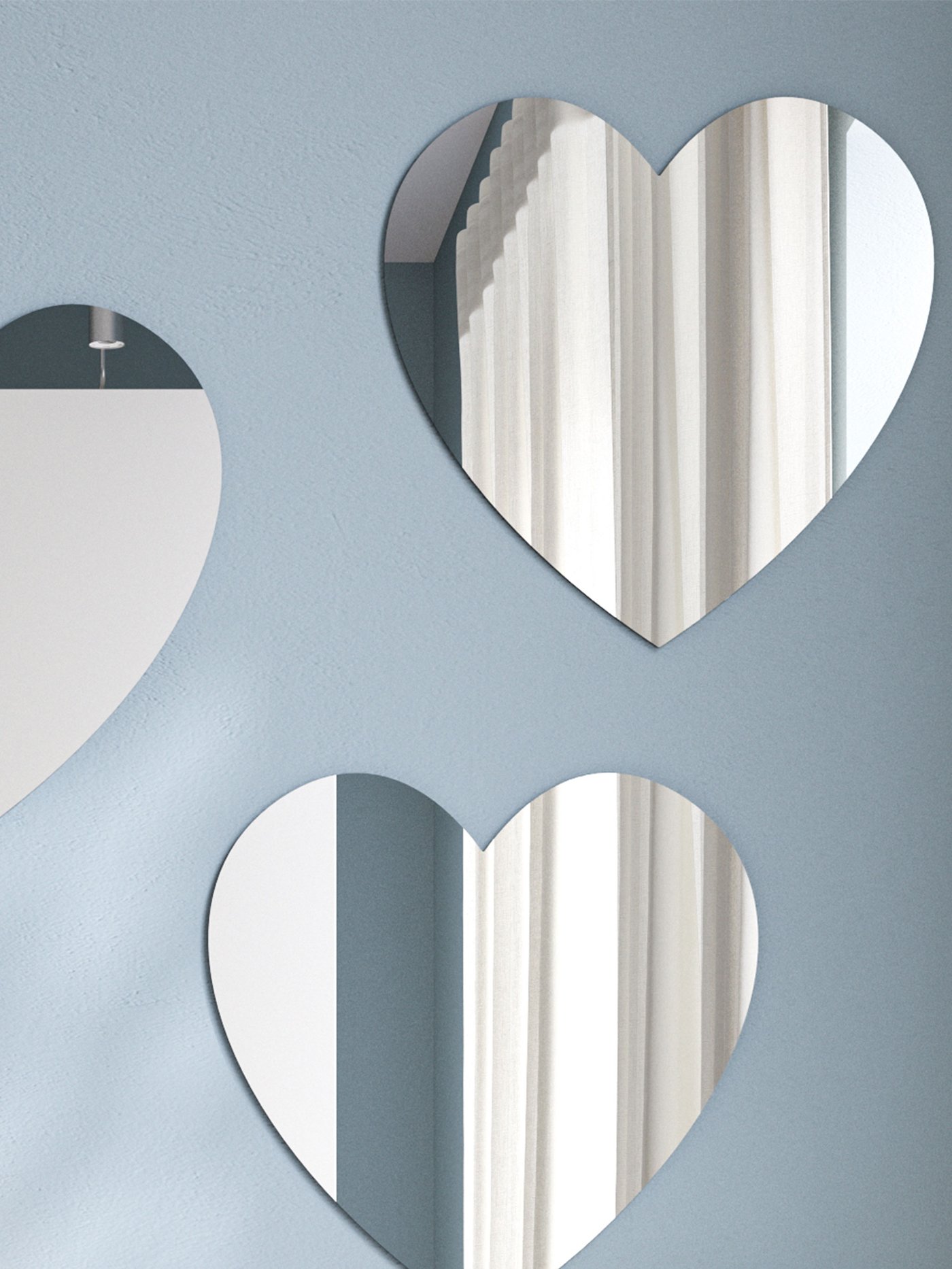 Ljusblå vägg med tre hjärformade speglar assymetristk placerade. 