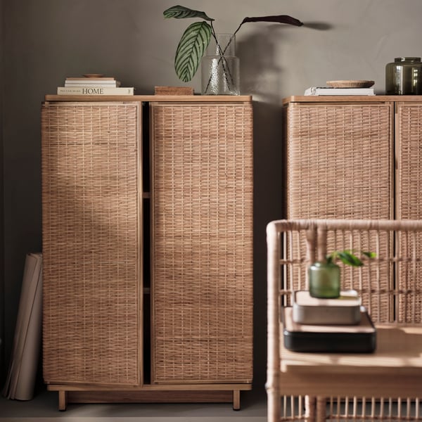 A wicker cabinet with a plant on top.