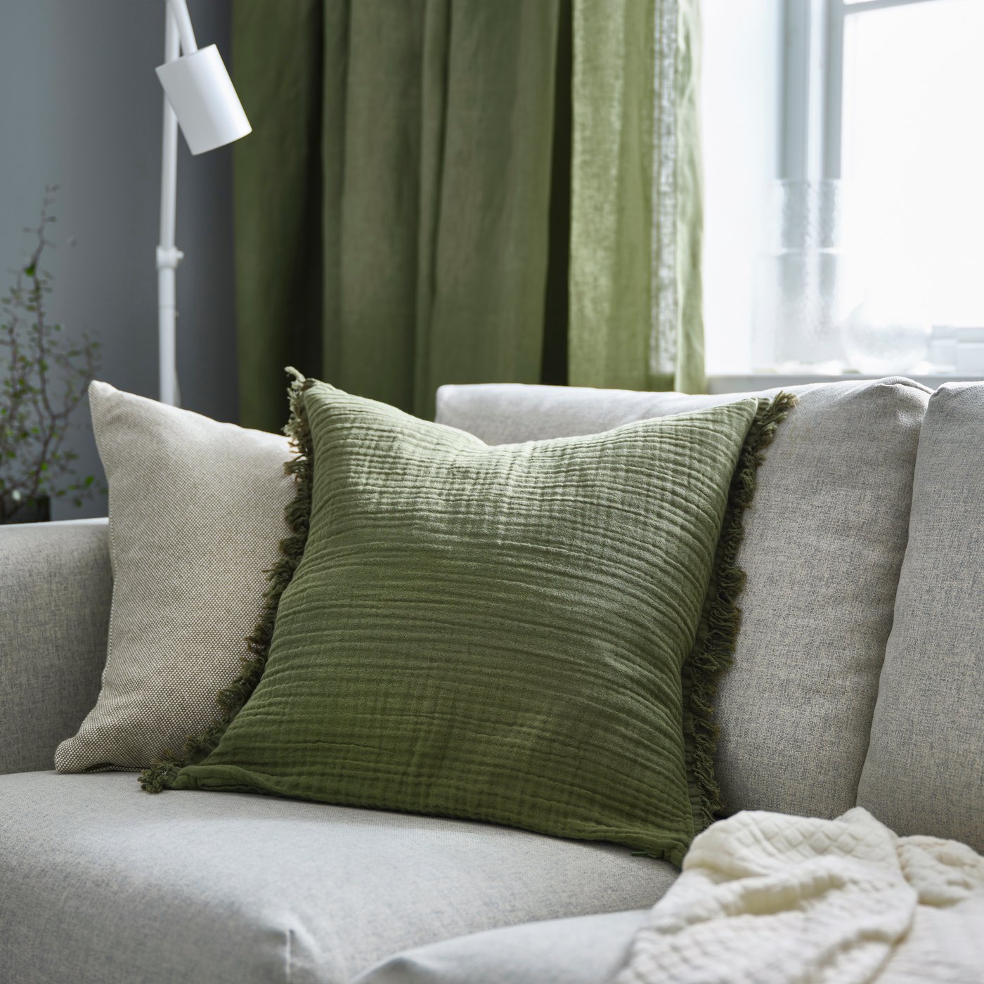 A grey-green VALLKRASSING cushion cover