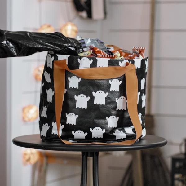 Video of KUSTFYR small FRAKTA bag stuffed with candy. Kids in costume extending arm and taking candy from bag