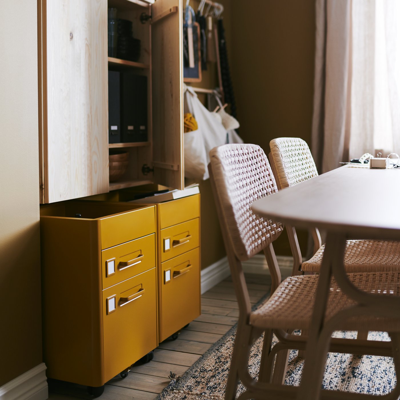 IDÅSEN drawer units on castors in golden-brown add flexible storage to a combined dining and workspace area.