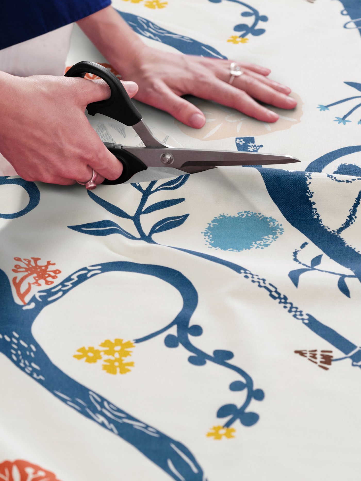 ìDettagli botanici/tessuto pretagliato REVFINGERÖRT bianco multicolore su un tavolo mentre viene tagliato con le forbici