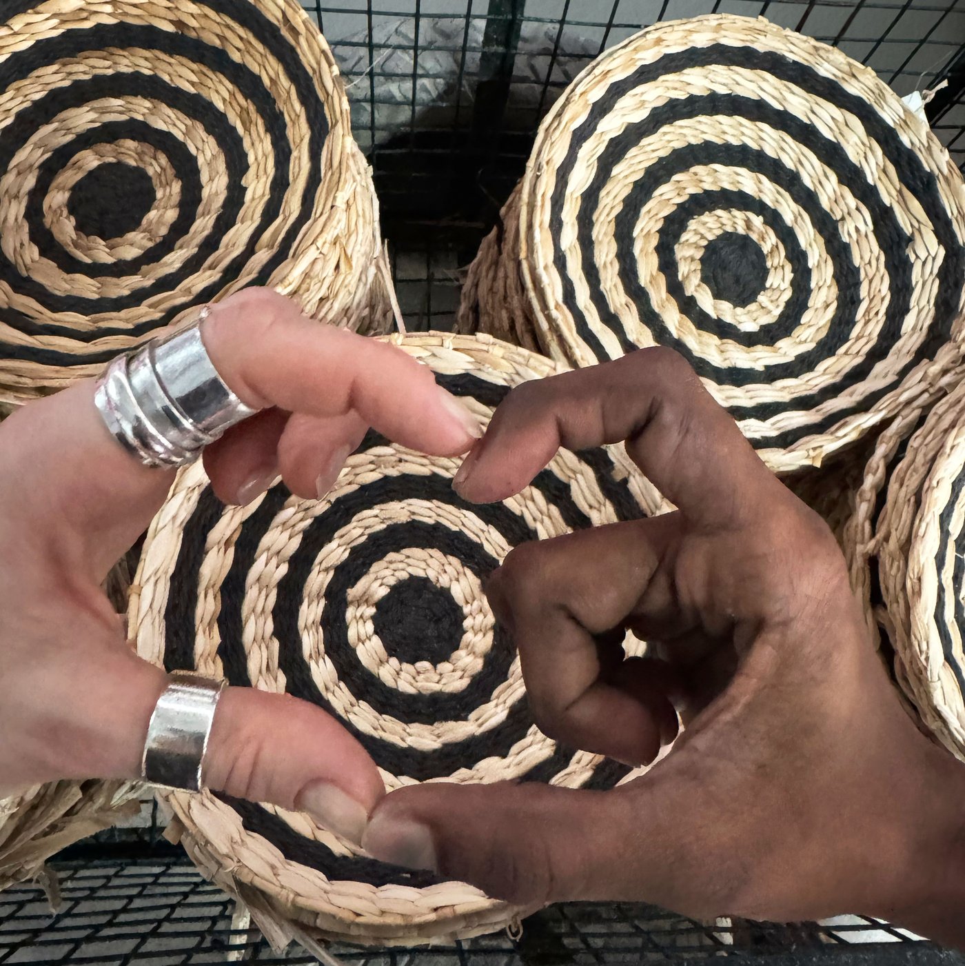 山積みになったMÄVINN/メーヴィン ウォールデコレーションの上で、肌の色が異なる2つの手を合わせてハートをつくっている。