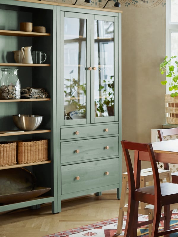 Una combinazione mobili HEMNES con cassetti e die ante di vetro posto in una cucina.
