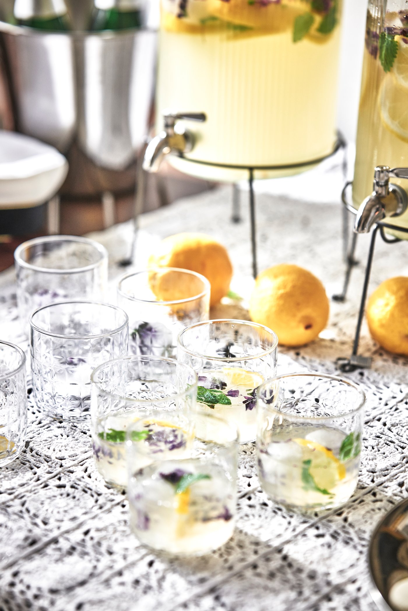 Ett bord med en behållare, citroner och glas.