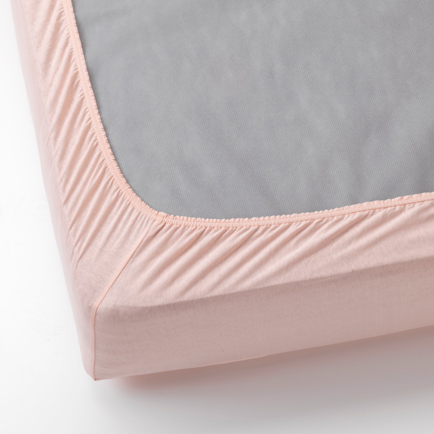 Drap housse rose sur un matelas retourné