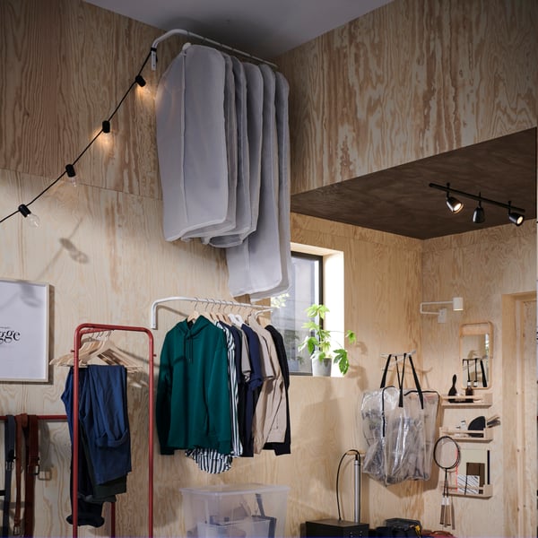 Une housse de vêtements STUK blanche/grise dans le couloir