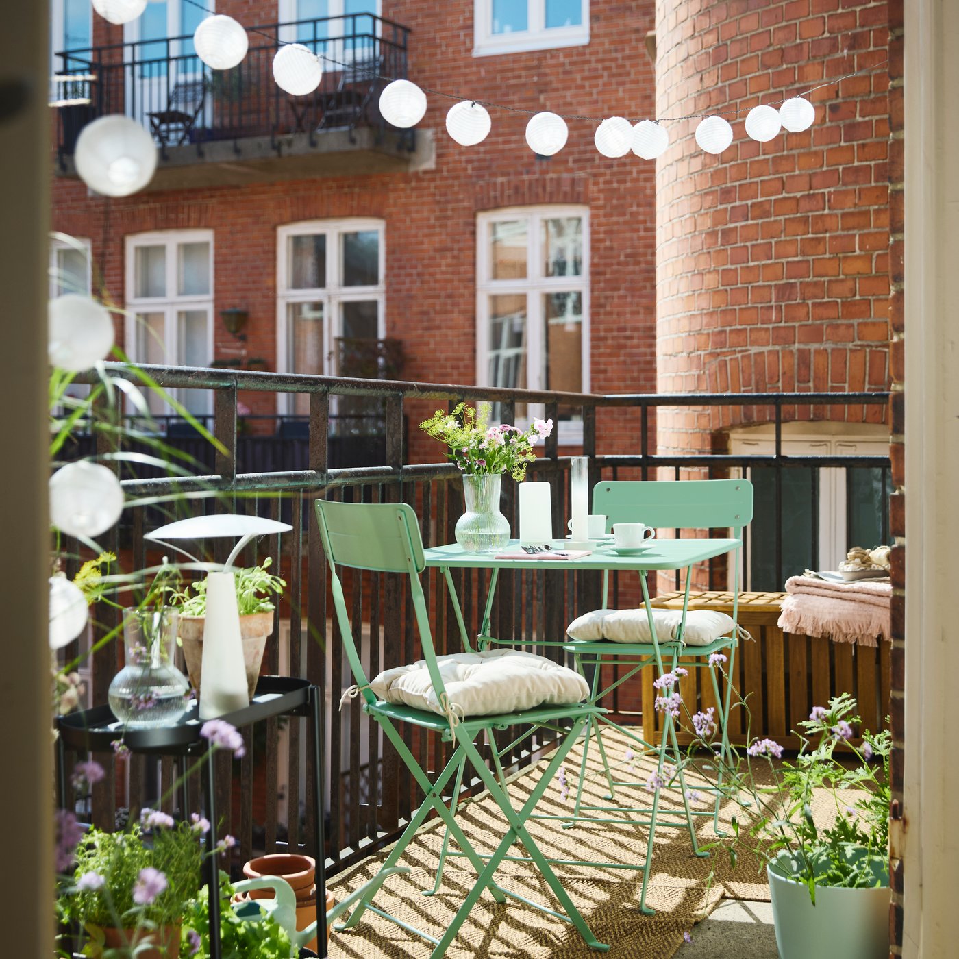 A light green folding SUNDSÖ outdoor chair on a sunny balcony.
