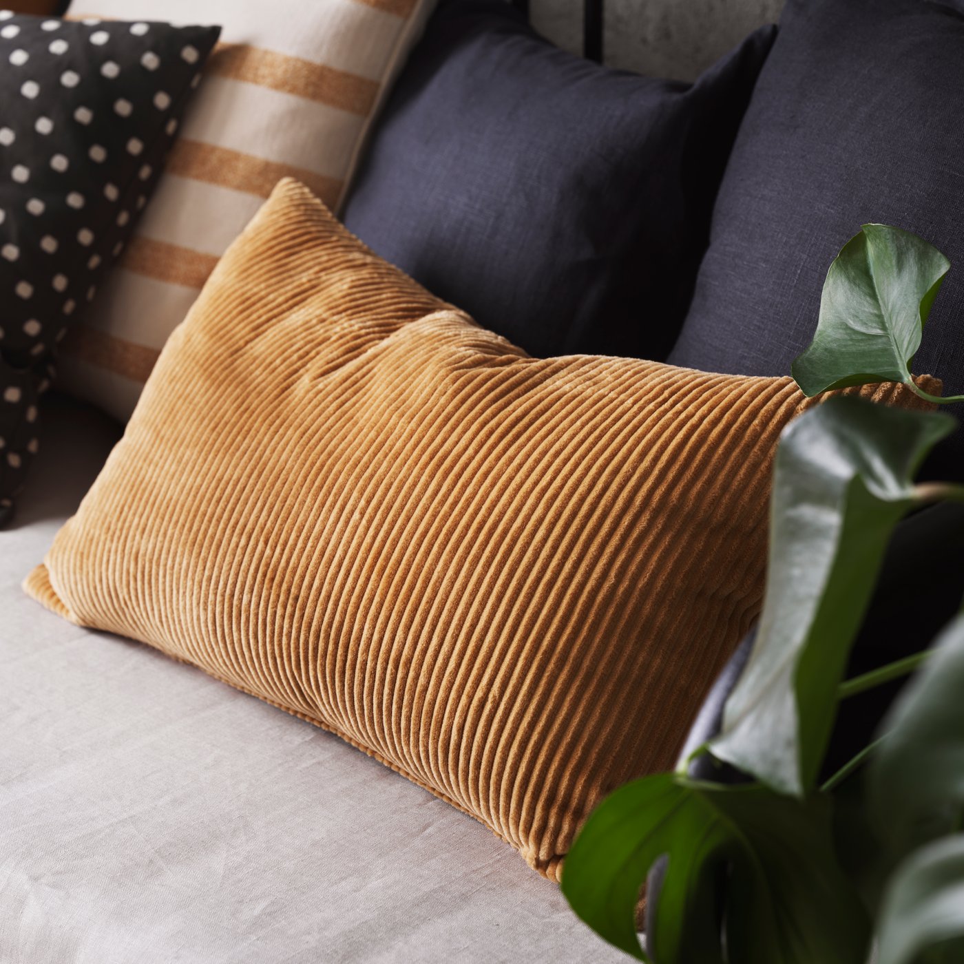 A dark beige ÅSVEIG cushion cover in the NA