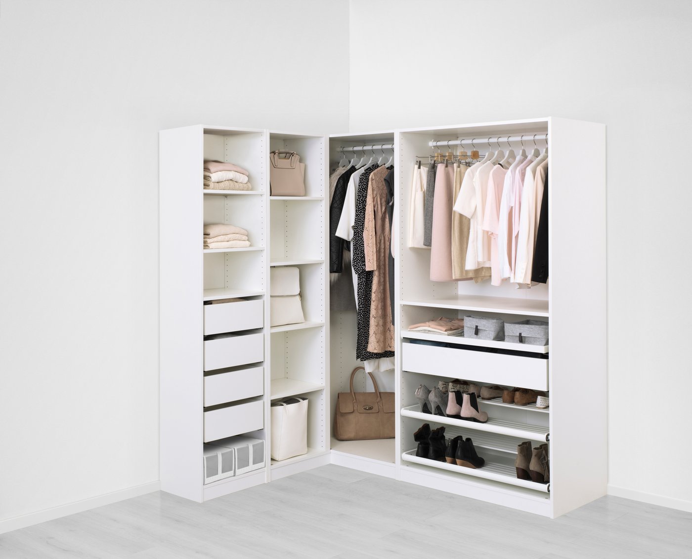 Bílá rohová šatní skříň s oblečením.