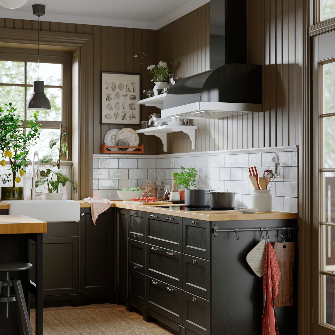 A kitchen with a black UNGDOMLIG wall mounted extractor hood above white tiles and dark cabinet fronts with a wooden worktop.