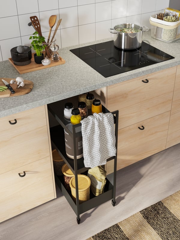 A kitchen setting featuring a SÄLJAN worktop, METOD drawers, NISSAFORS trolley that is slightly ajar.