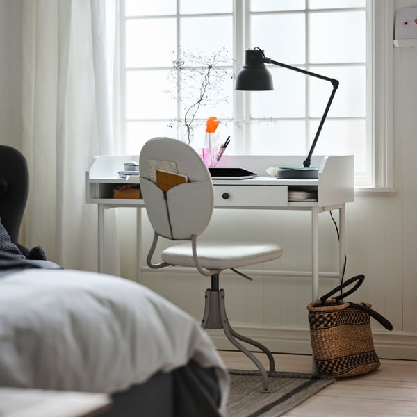 A dark grey HEKTAR work lamp with wireless charging in the home office