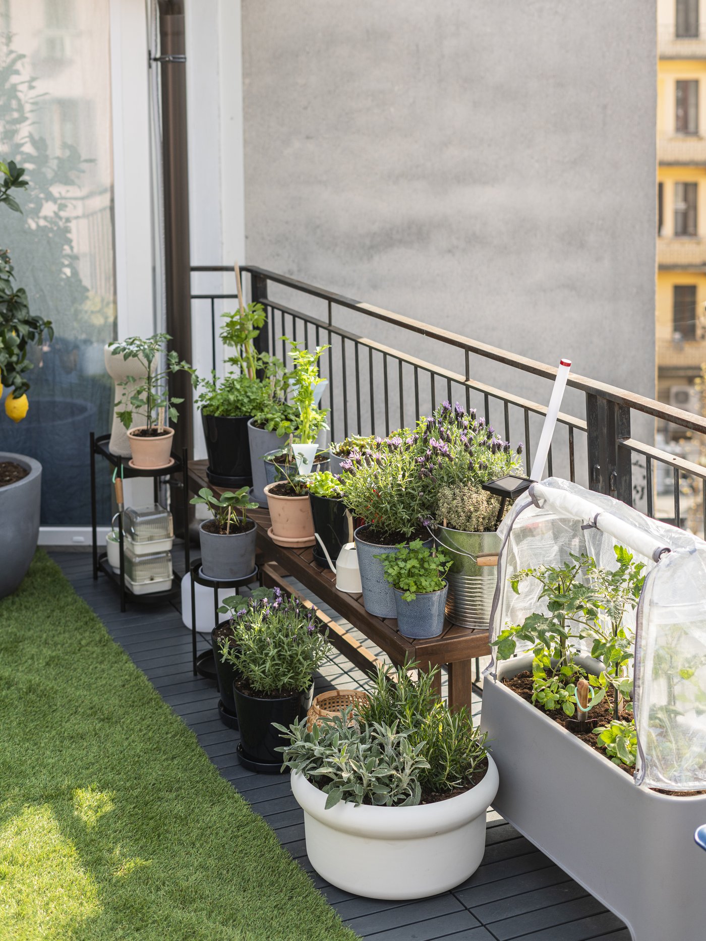 Spazio esterno con diversi portapiante OLIVBLAD nero da interno/esterno, ideale per esporre vasi e piante su balconi, terrazze e in casa.