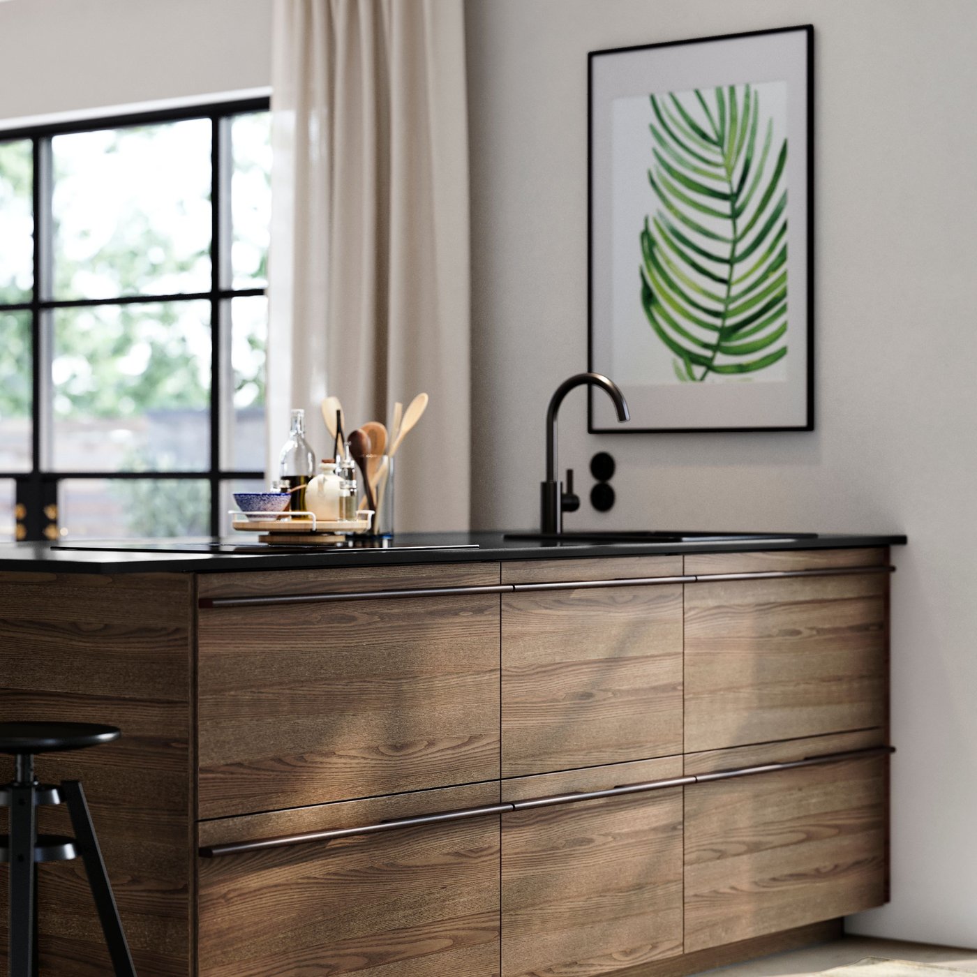 En ljus och ljus köksinredning med köksö med STENSTA mörkbruna askfanerfronter och svart kran.