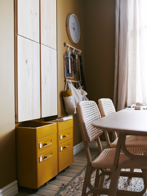 Two golden brown IDÅSEN drawer units on castors slot in below wall-mounted IVAR cabinets in pine.
