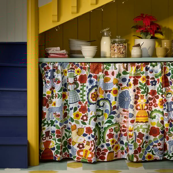Rideau multicolore à motifs confectionné à partir de tissu précoupé CINTIAKAKTUS, sous un comptoir de cuisine.