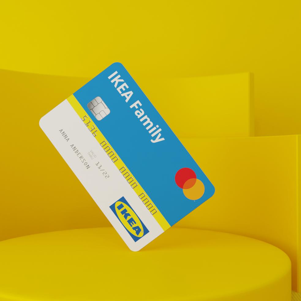 Eine blau-weisse IKEA Family Karte mit Chip und Mastercard-Logo schwebt vor einem leuchtend gelben Hintergrund. Der sichtbare Name auf der Karte lautet „Anna Anderson“.