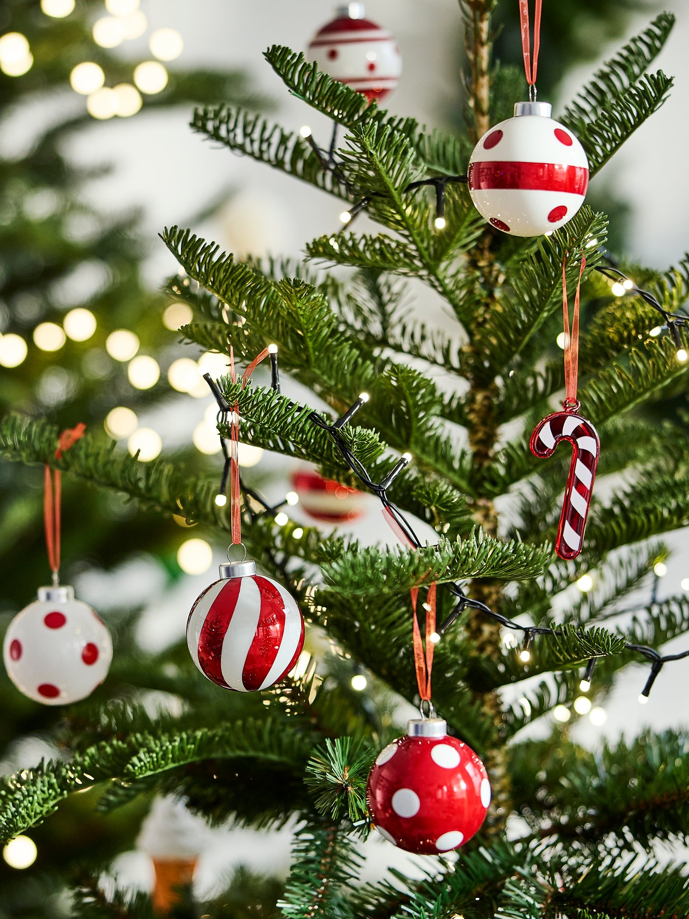 Geschmückter Weihnachtsbaum mit roten und weißen Kugeln, Zuckerstangen und weiteren festlichen Anhängern.
