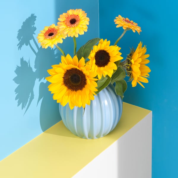 A light blue SKOGSTUNDRA vase