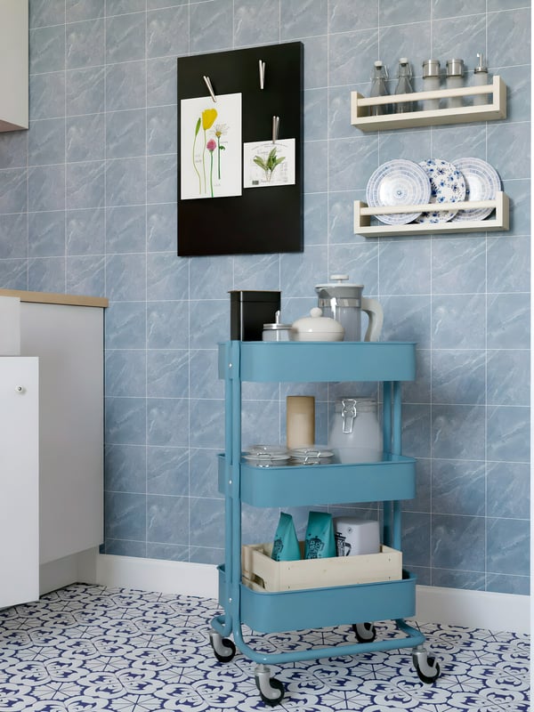 A grey-blue RÅSKOG trolley filled with well-organised cookware in a kitchen