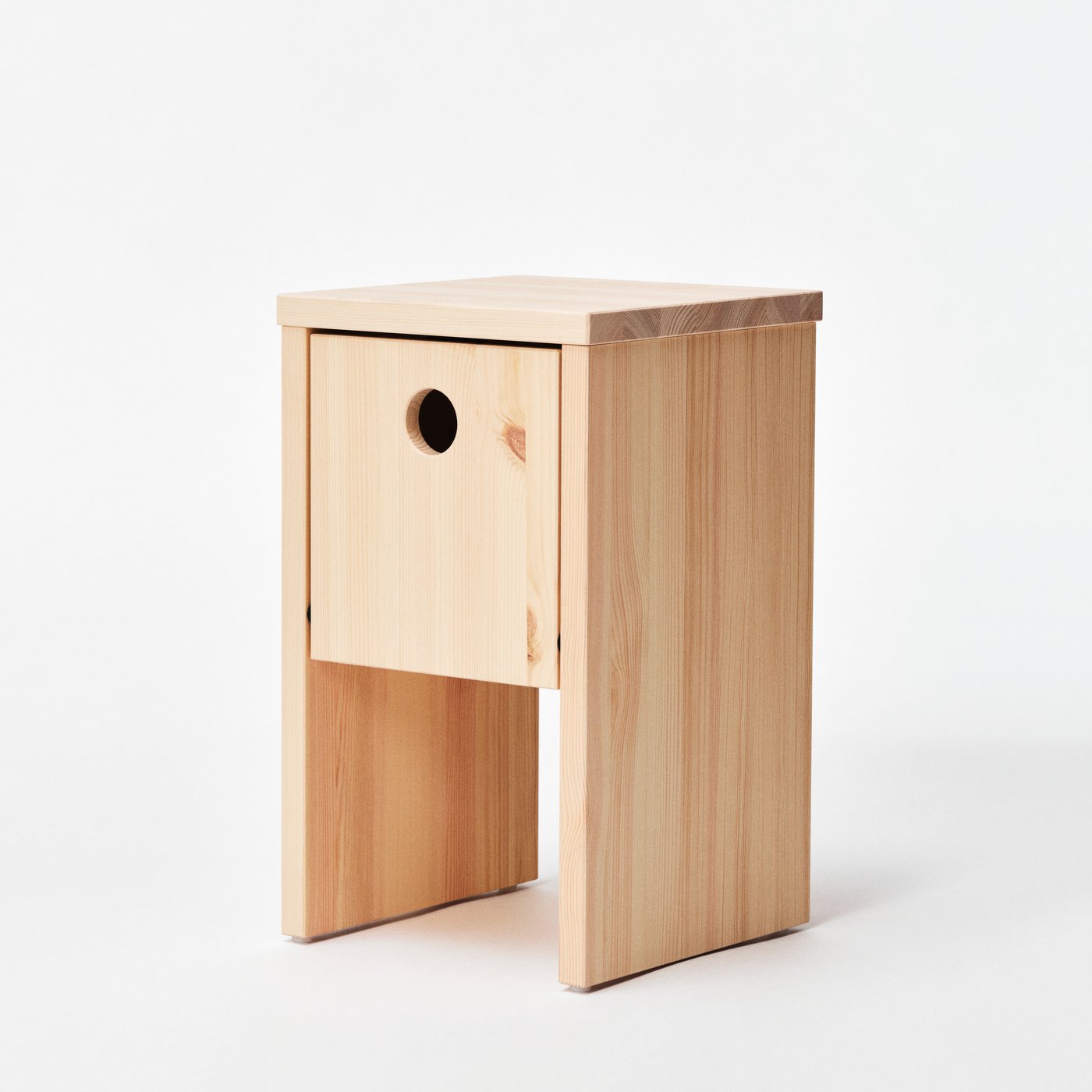 A solid pine IKEA PS 2026 bedside table that has storage and built-in cable management.